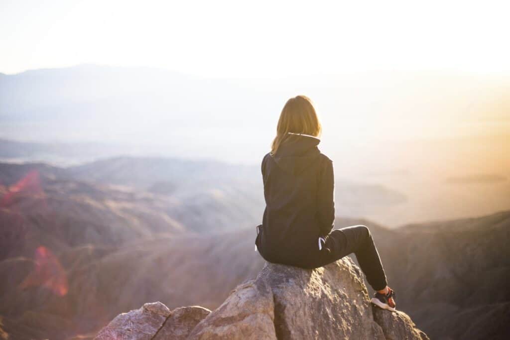 Person sitting on the top of a mountain