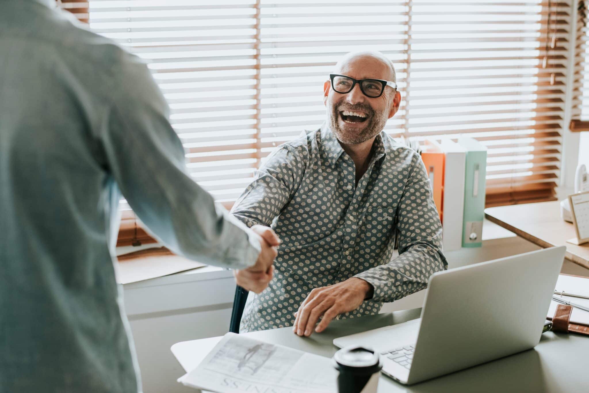 Businessman in an office shaking hands, on demand management training